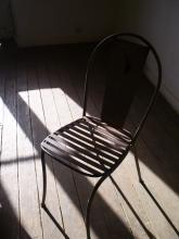 A chair bathed in light and shadows
