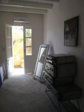 A room with a mirror and a set of drawers