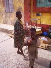 2 children, outside, one holding a can