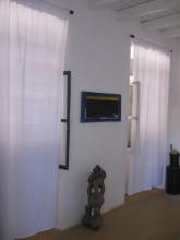 A wall with two curtained windows