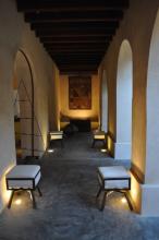 A hallway with arched doorways and seats on either side